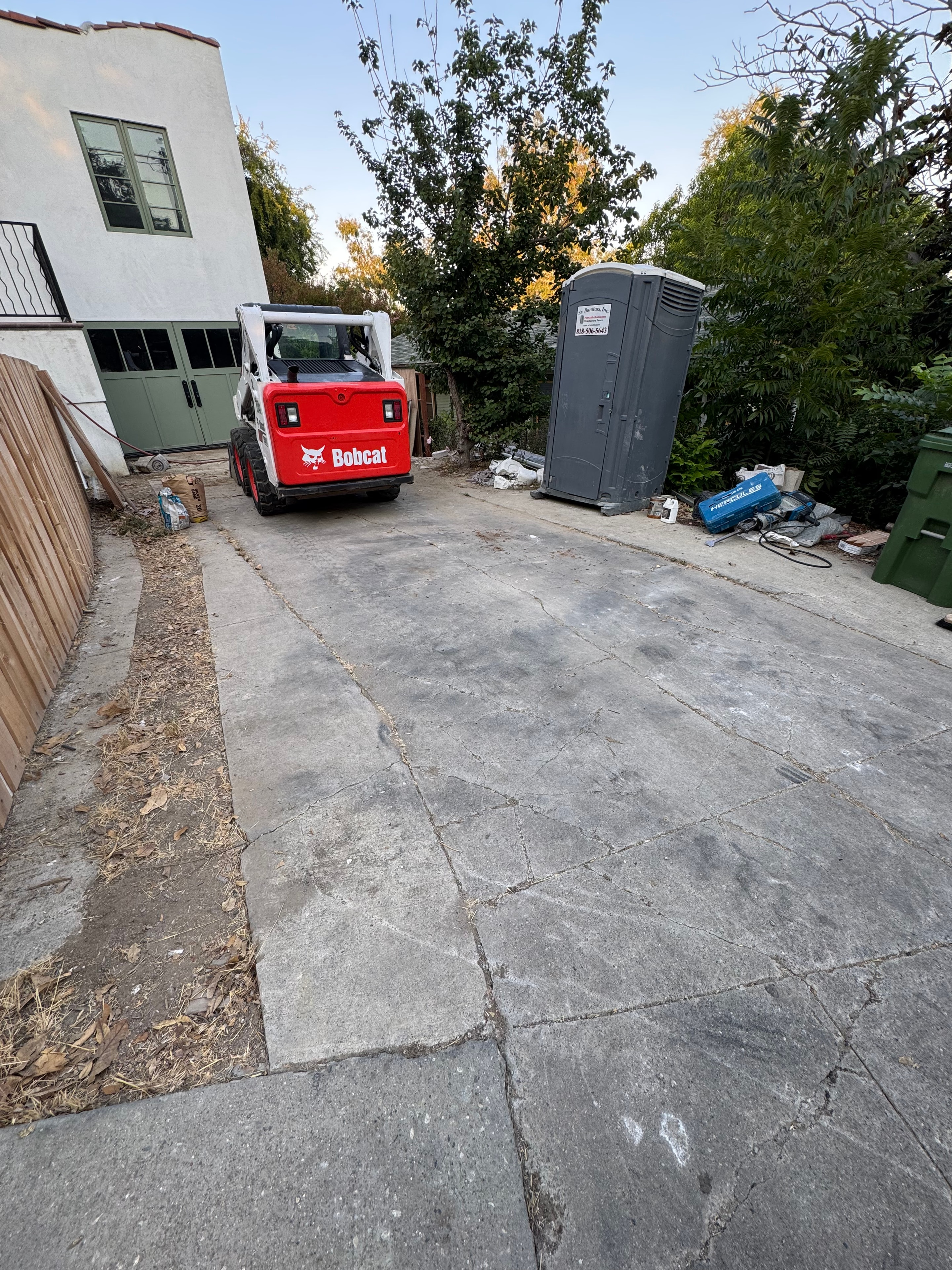 Cracked concrete driveway with Bobcat excavator on site, Los Angeles County — Concrete Etc., Inc.