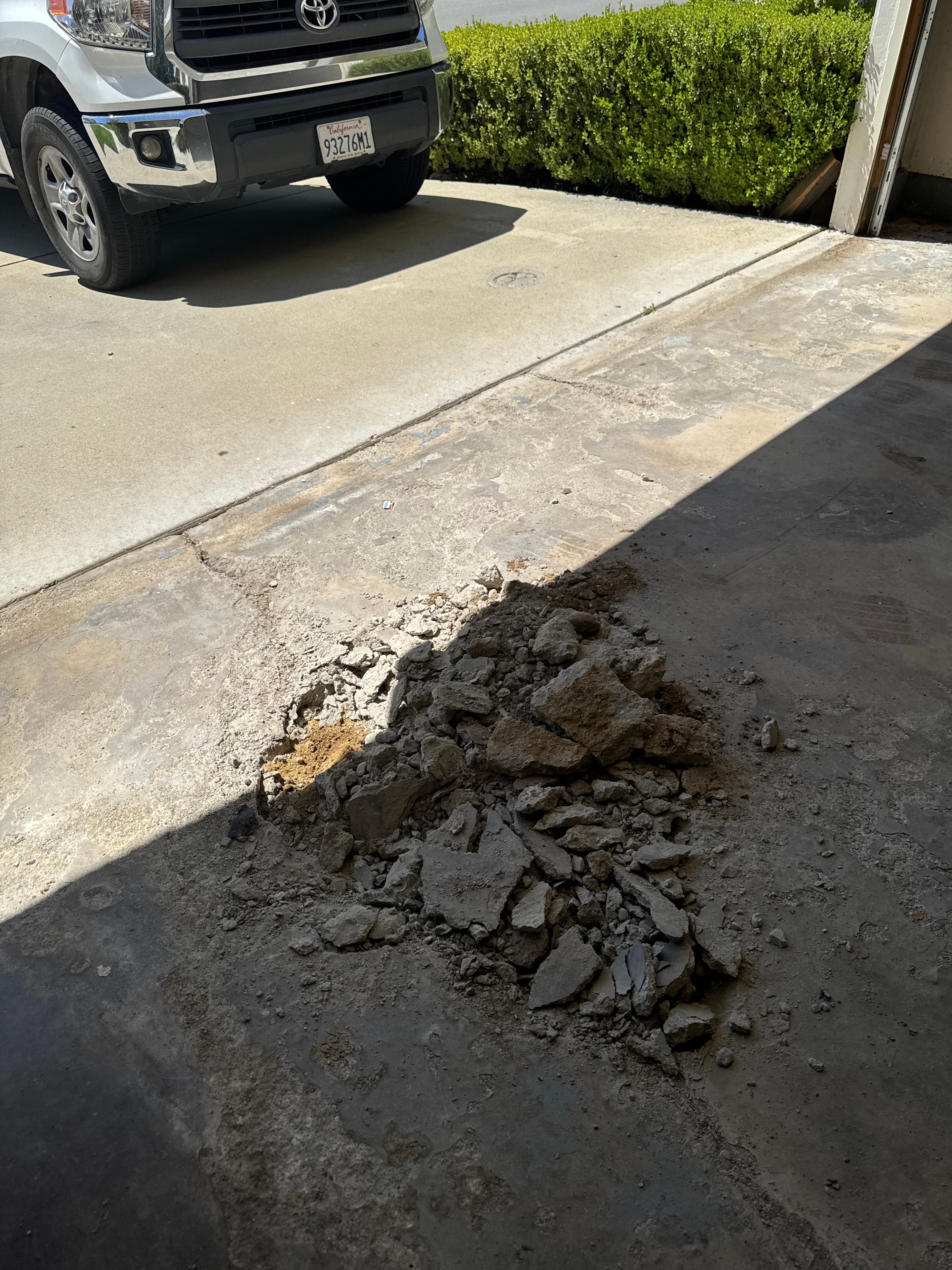Test pit excavated through cracked concrete garage slab revealing soil conditions, Los Angeles County — Concrete Etc., Inc.