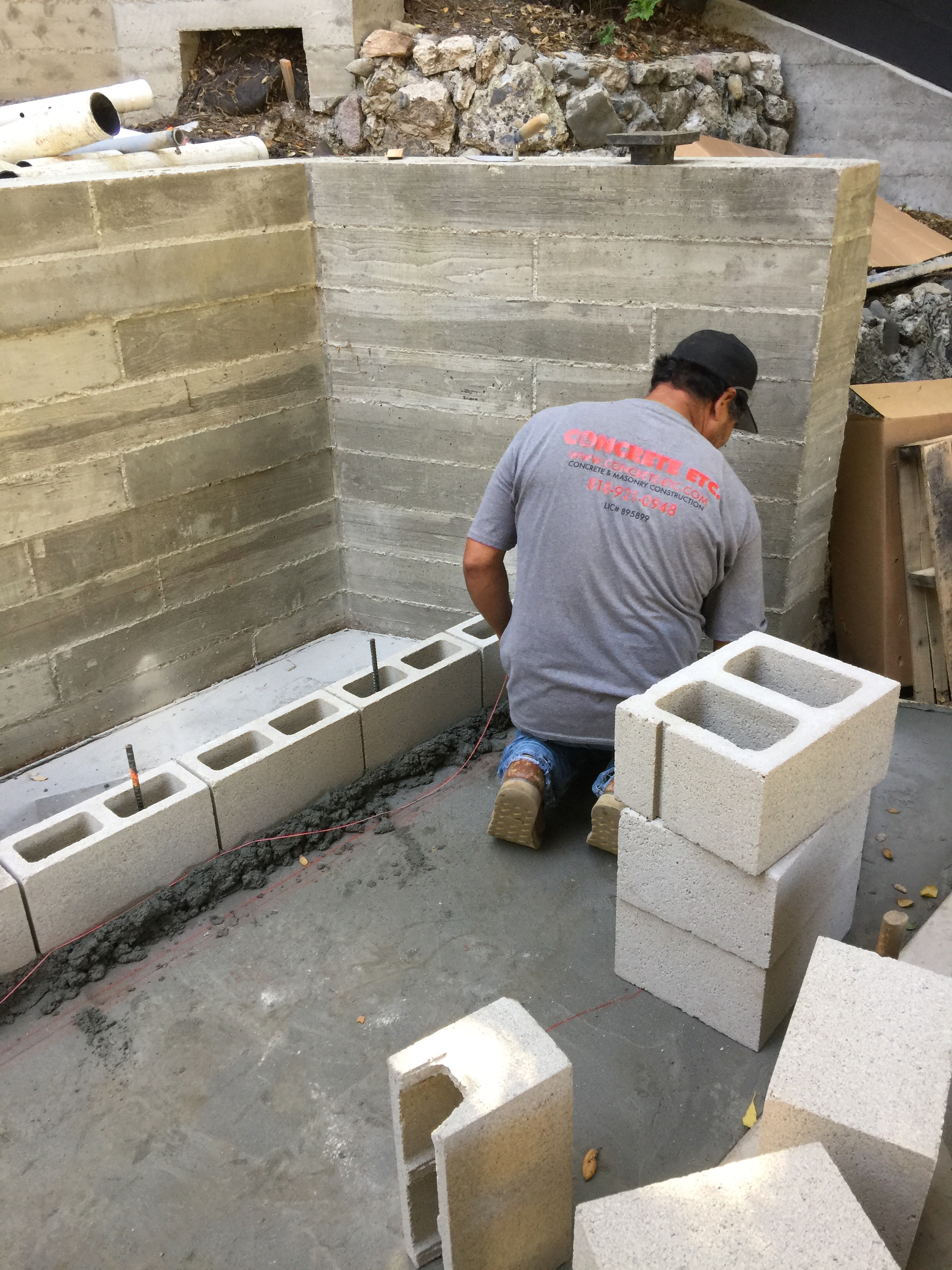 Concrete Etc. mason laying CMU block on hillside foundation project in Pacific Palisades, Los Angeles County CA