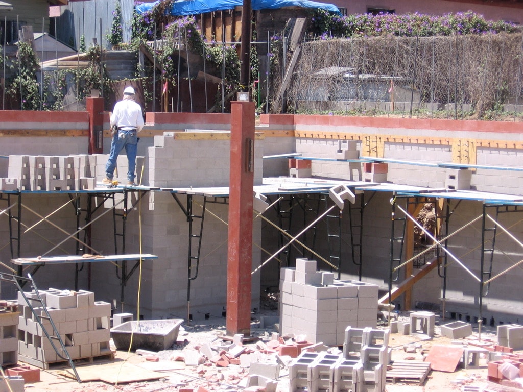Commercial ground-up construction with CMU block walls, steel columns and scaffolding on concrete foundation in Los Angeles by Concrete Etc., Inc.