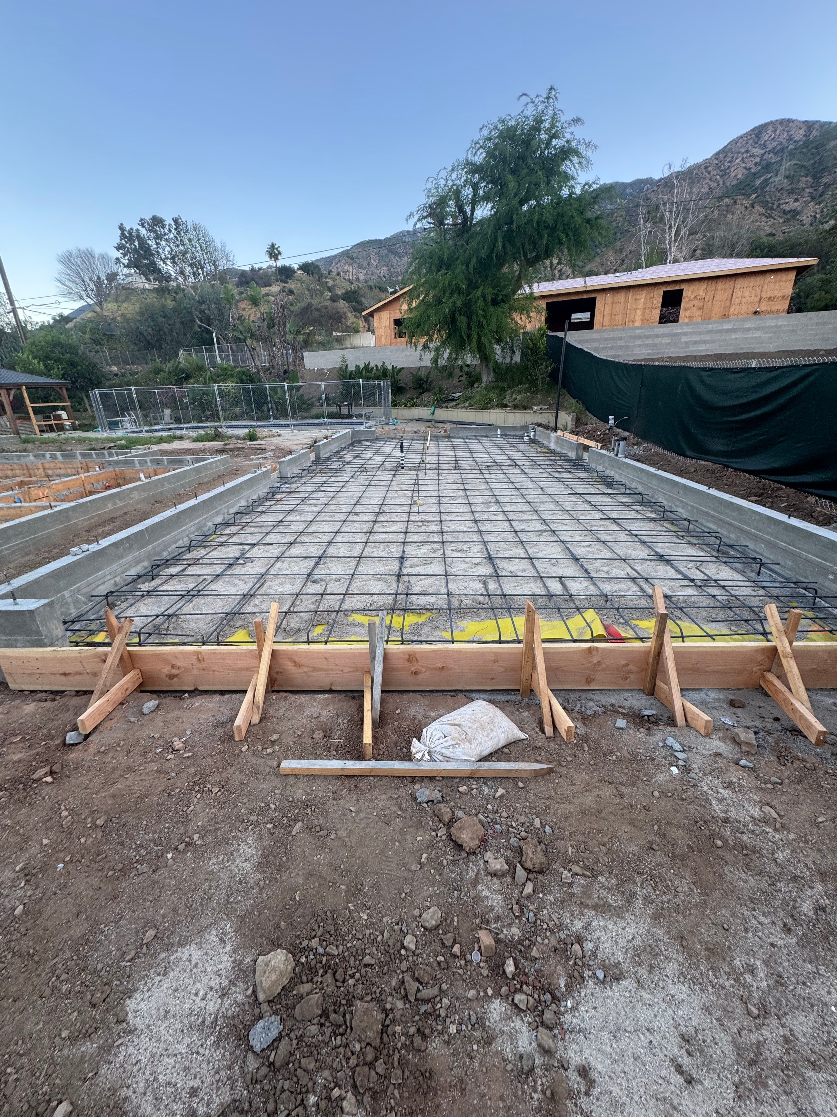 Structural concrete slab foundation with wire mesh reinforcement and wood formwork under construction in Altadena, CA by Concrete Etc., Inc.