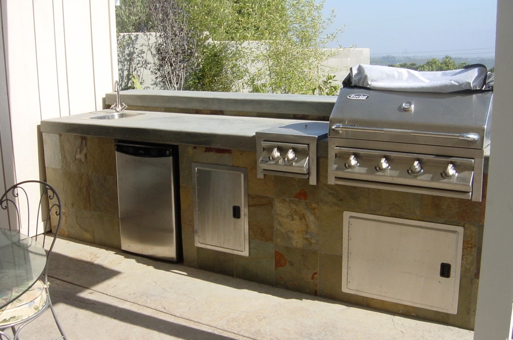 Outdoor kitchen with stucco finish, Viking grill, concrete countertop and flagstone patio in Los Angeles by Concrete Etc., Inc.
