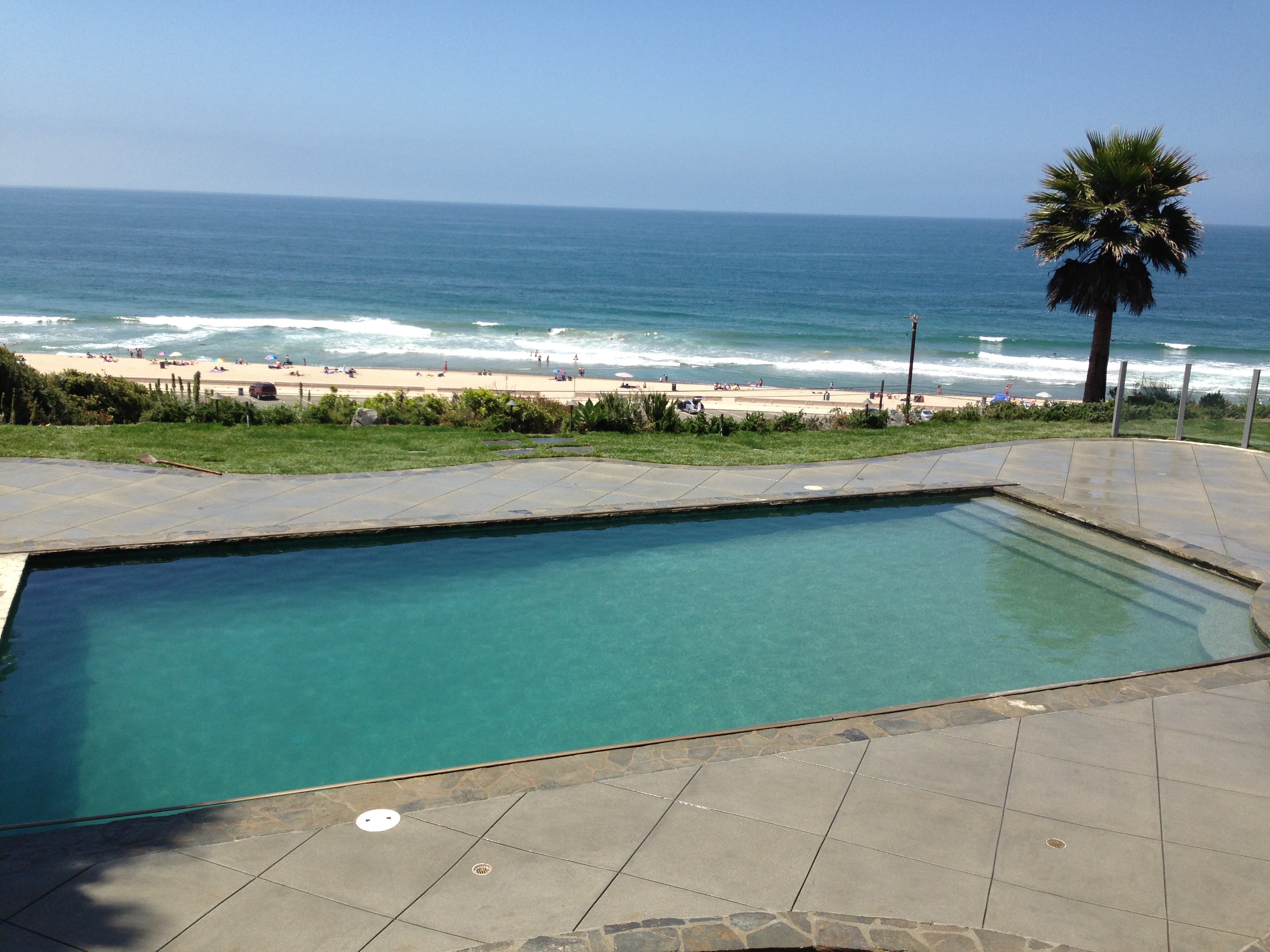 Beachfront flagstone and sand finish concrete pool deck on oceanfront property in Malibu, CA by Concrete Etc., Inc.