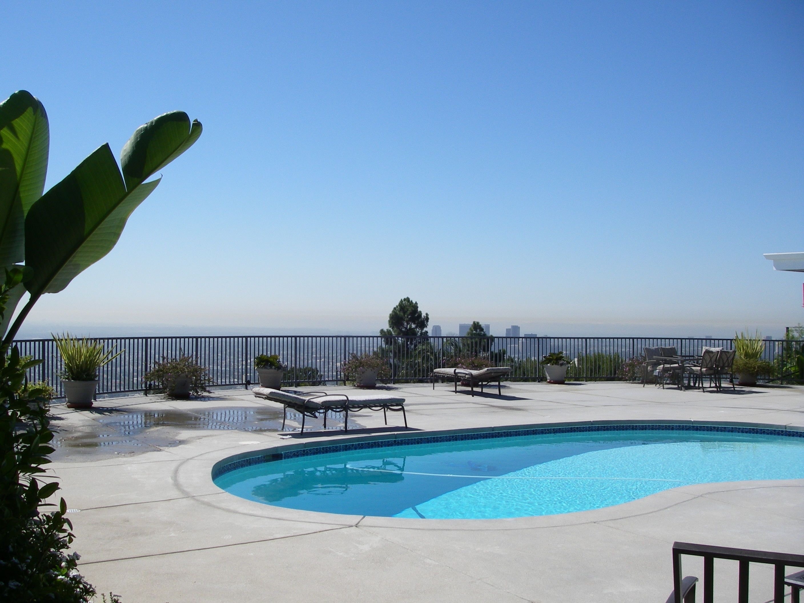 Smooth sand finish concrete pool deck with city views and lounge area on hillside property in Los Angeles by Concrete Etc., Inc.