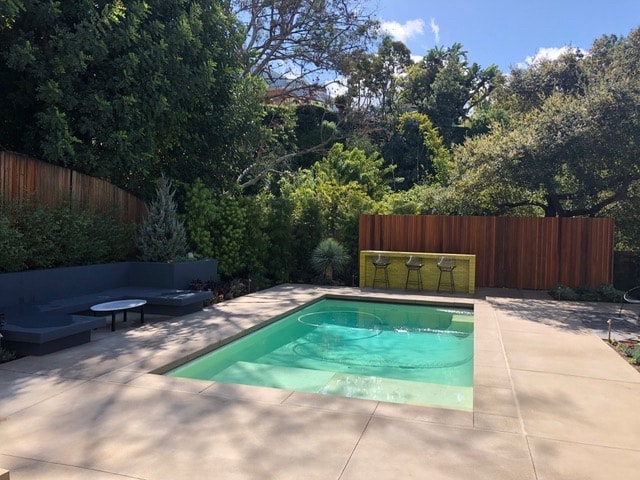 Sand finish concrete pool deck with coping and poured-in-place concrete bar installed in Beverly Hills, CA by Concrete Etc., Inc.