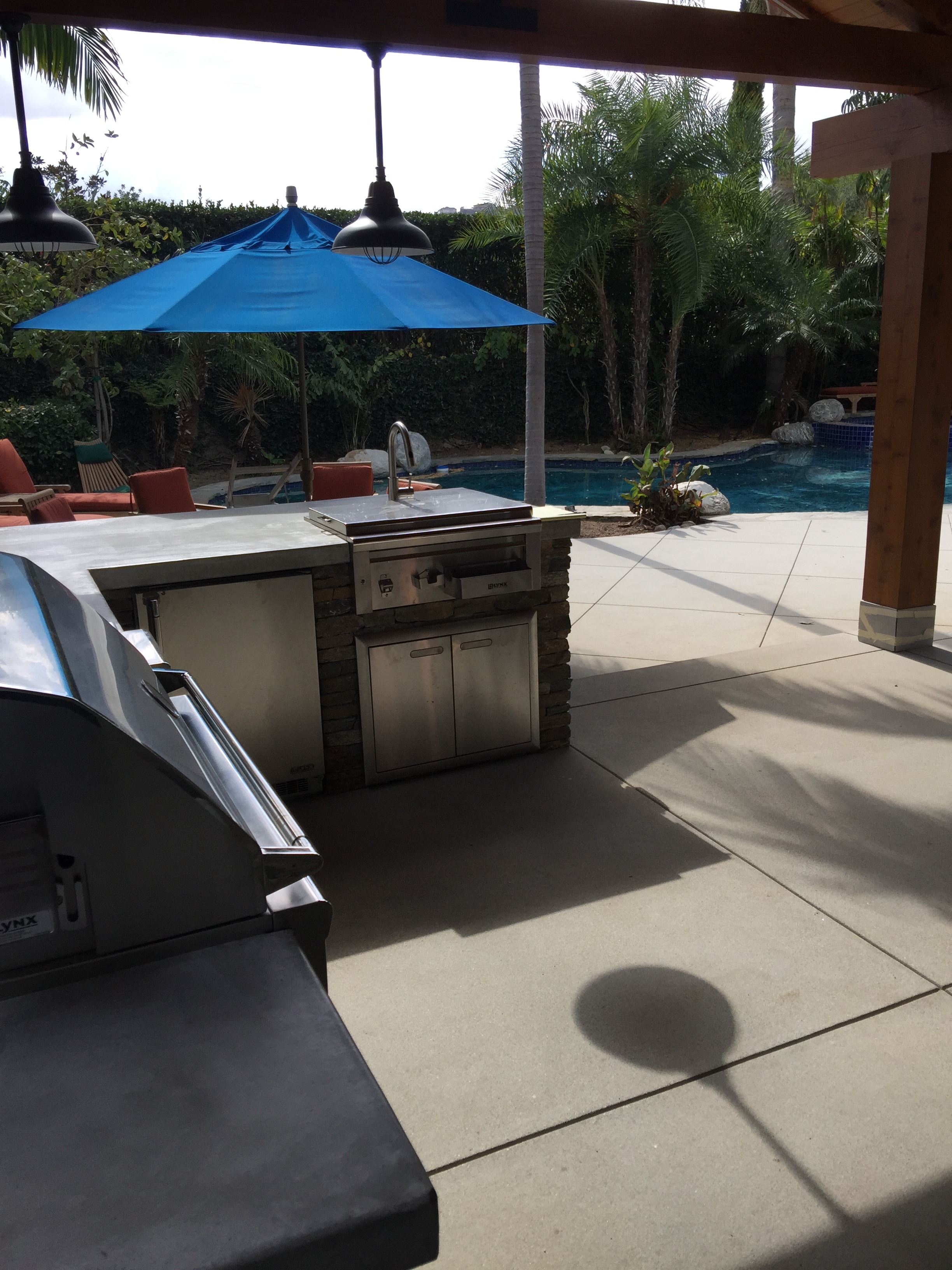 Sand finish concrete pool deck with outdoor living patio, pergola and built-in BBQ installed in Pasadena, CA by Concrete Etc., Inc.