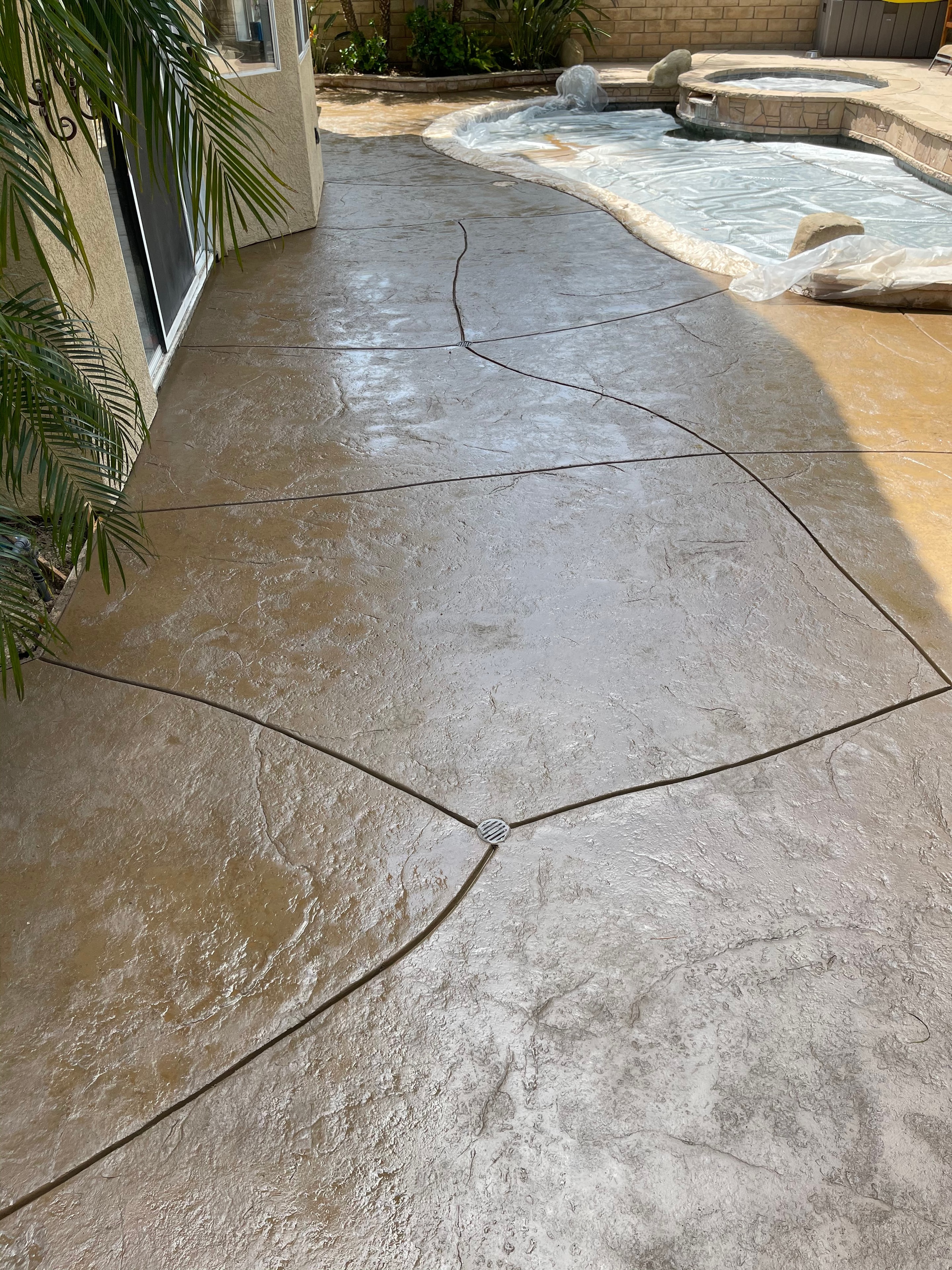 Stamped concrete pool deck with custom crazy cut control joints installed in Santa Clarita, CA by Concrete Etc., Inc.