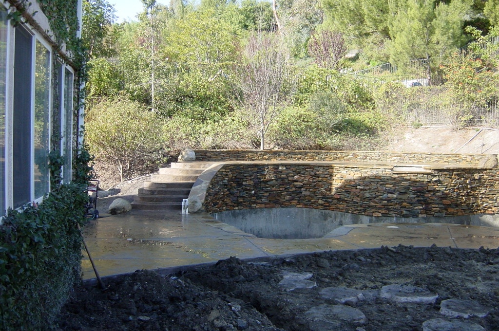 Stamped concrete pool deck with natural stone veneer installed in Los Angeles by Concrete Etc., Inc.