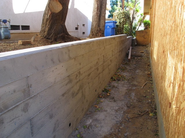 Board formed poured in place concrete retaining wall with weep holes installed in Brentwood, CA by Concrete Etc., Inc.