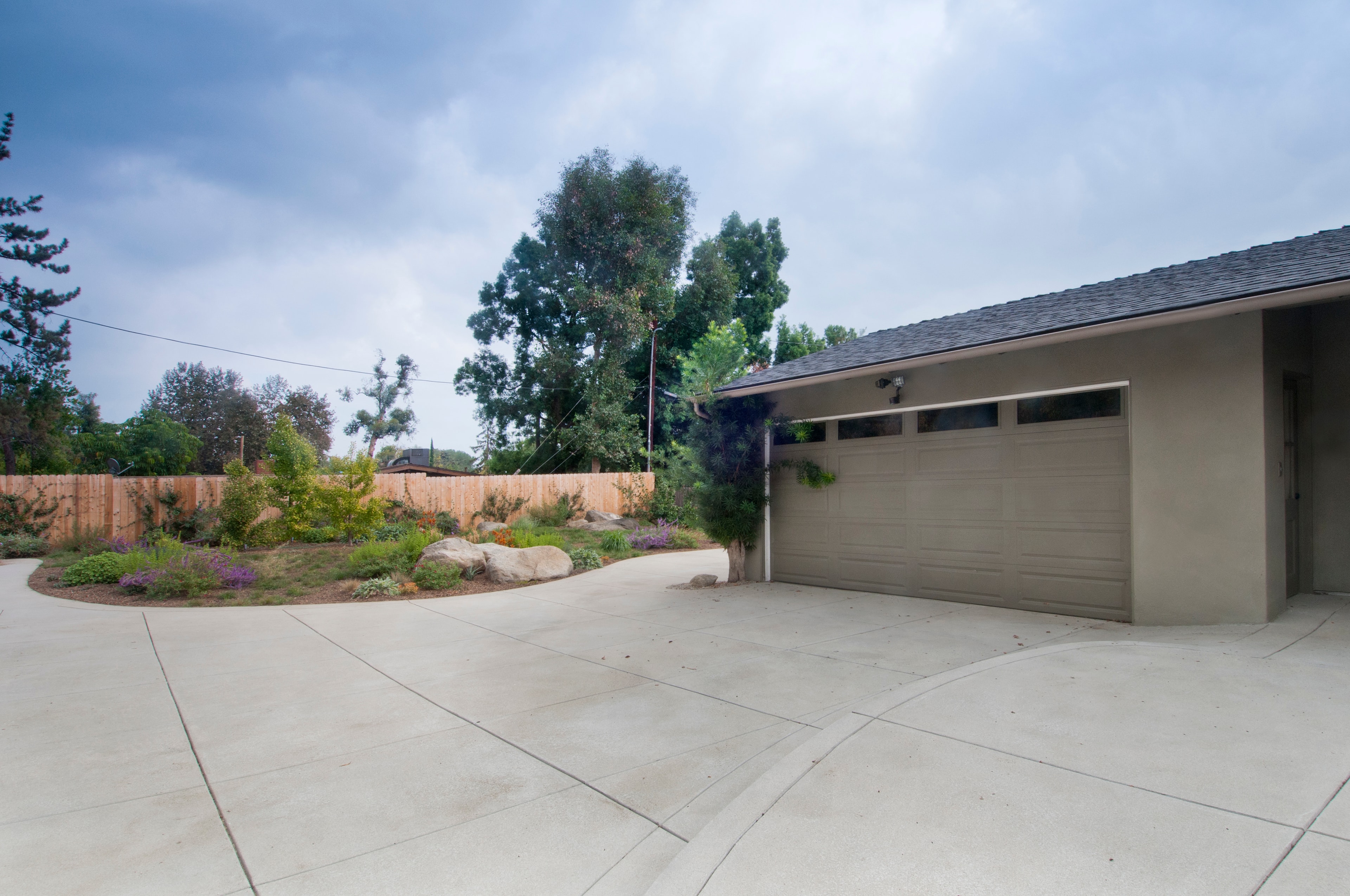 Sand finish concrete driveway with clean flatwork and landscaping in Sierra Madre, CA by Concrete Etc., Inc.